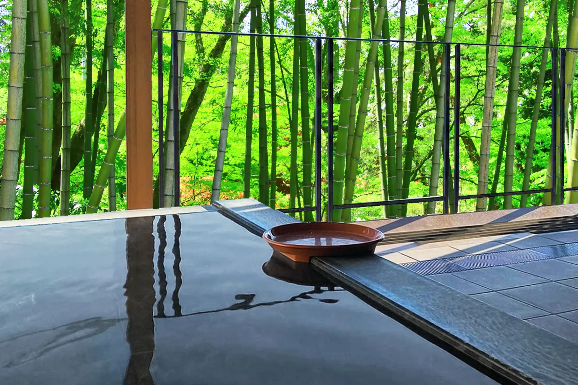 A quiet outdoor onsen bath framed by a bamboo grove in rural Japan