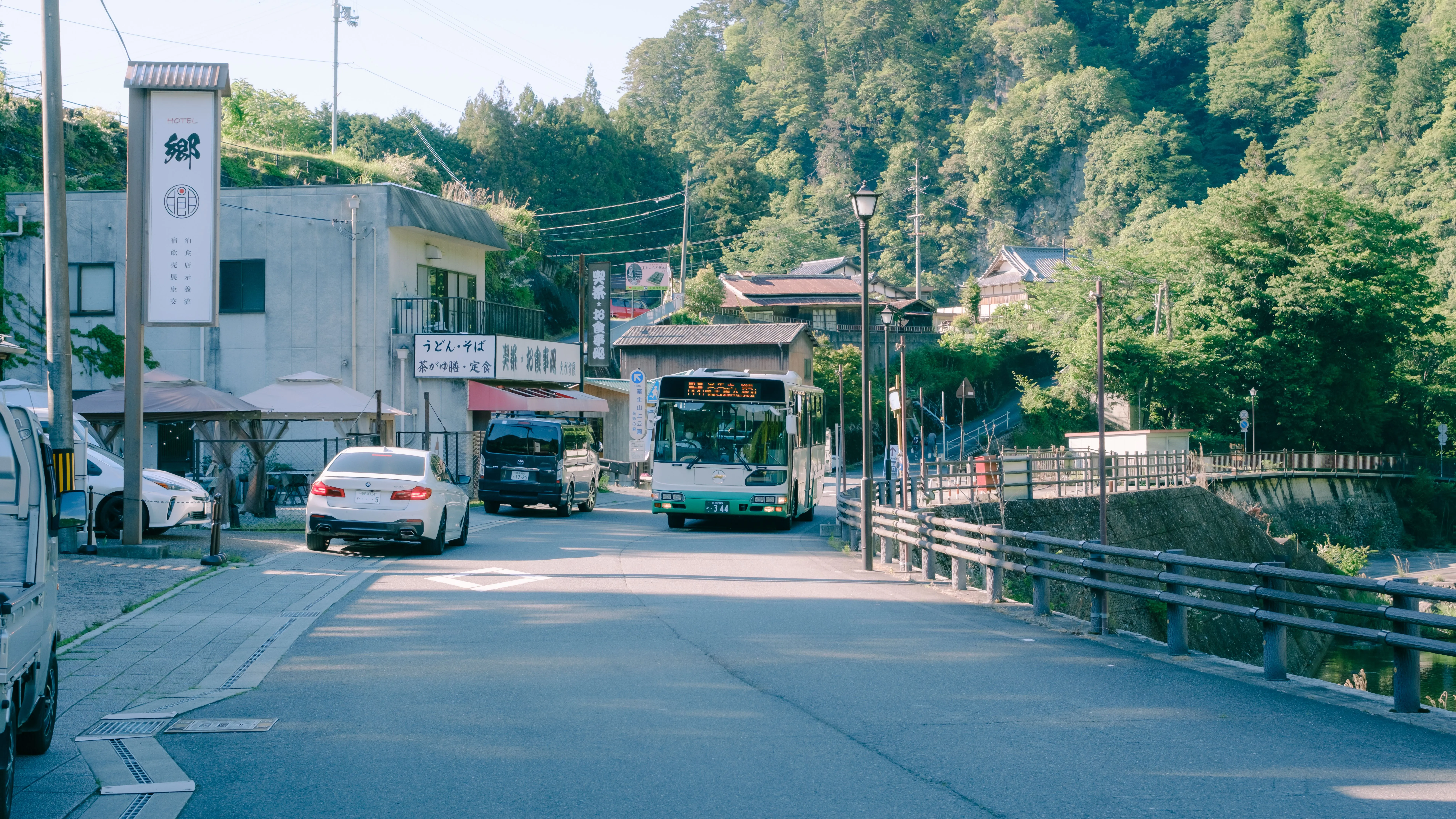 A rural Japanese bus stop with a printed timetable in the late afternoon